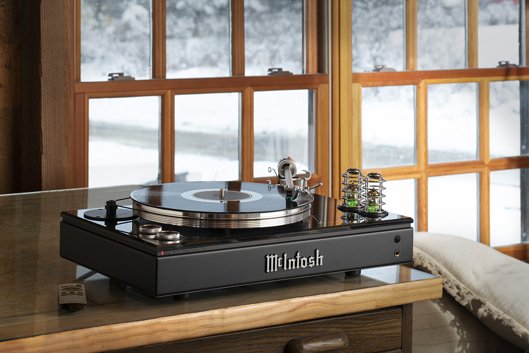 Black Mcintosh turntable over a wood dresser with a window in the back showing snow