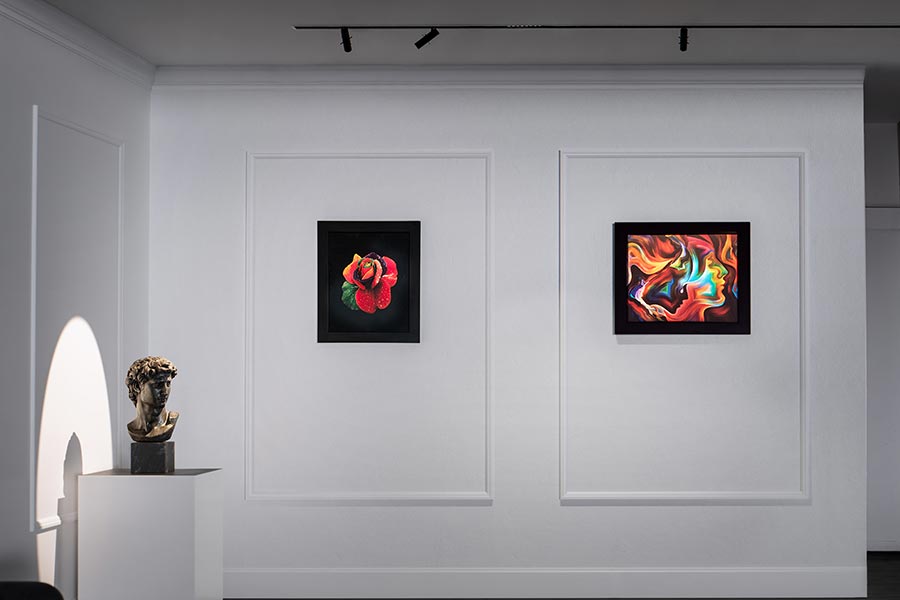Focused lighting highlights two framed artworks on a gallery wall