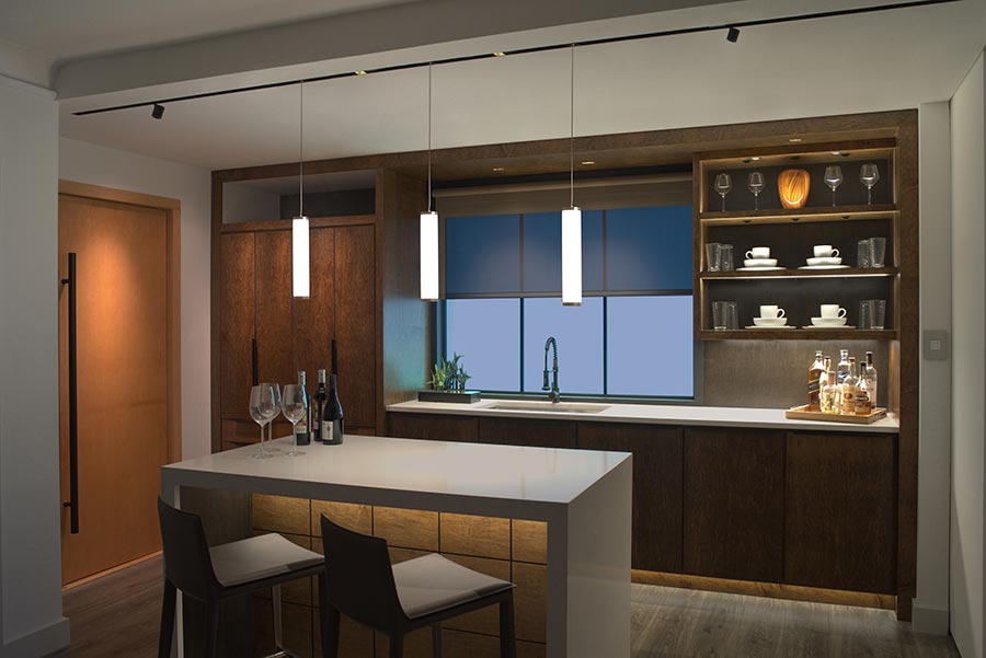 Pendant lights enhance a cozy kitchen with wood cabinetry