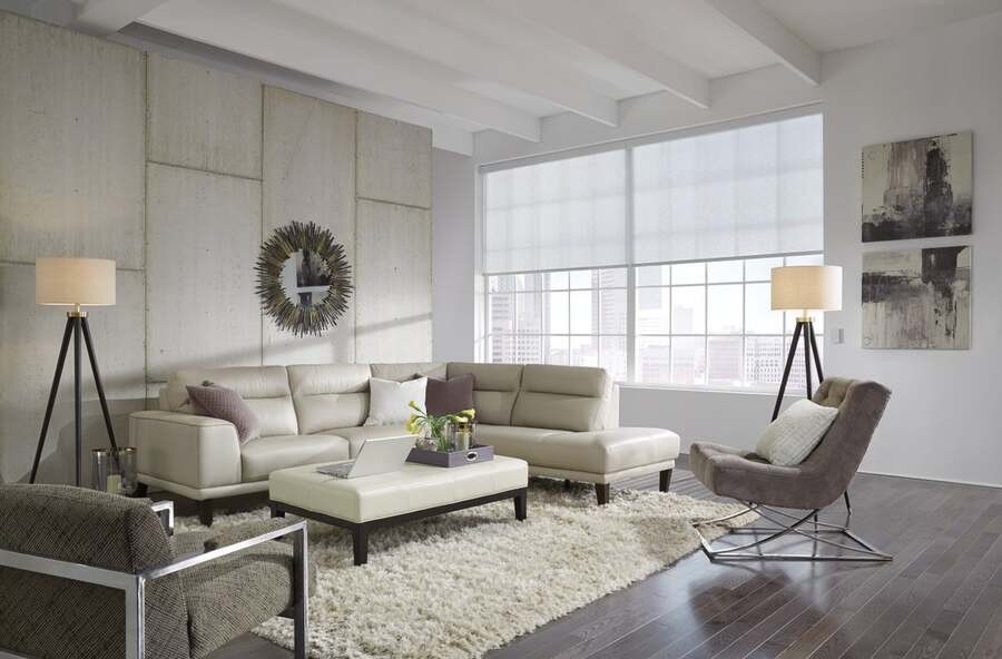 A luxurious living room with Lutron motorized shades rolled halfway down.