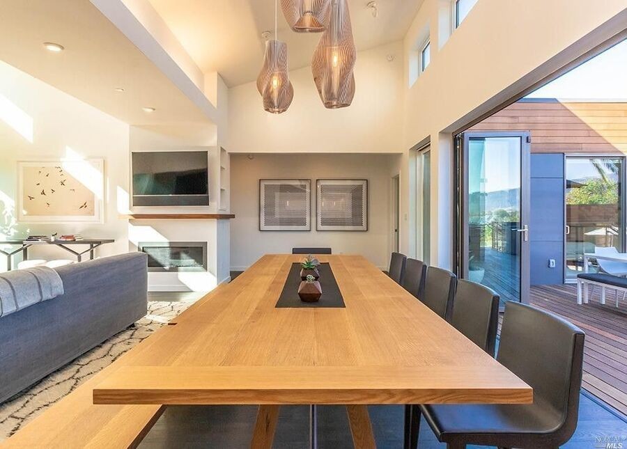 A luxury living room with Lutron motorized shades halfway down, overlooking a garden.