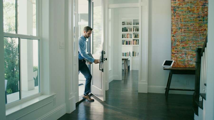 A man walks into his home after using his home access control system.