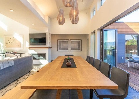  a dining room with a wooden table and black chairs.