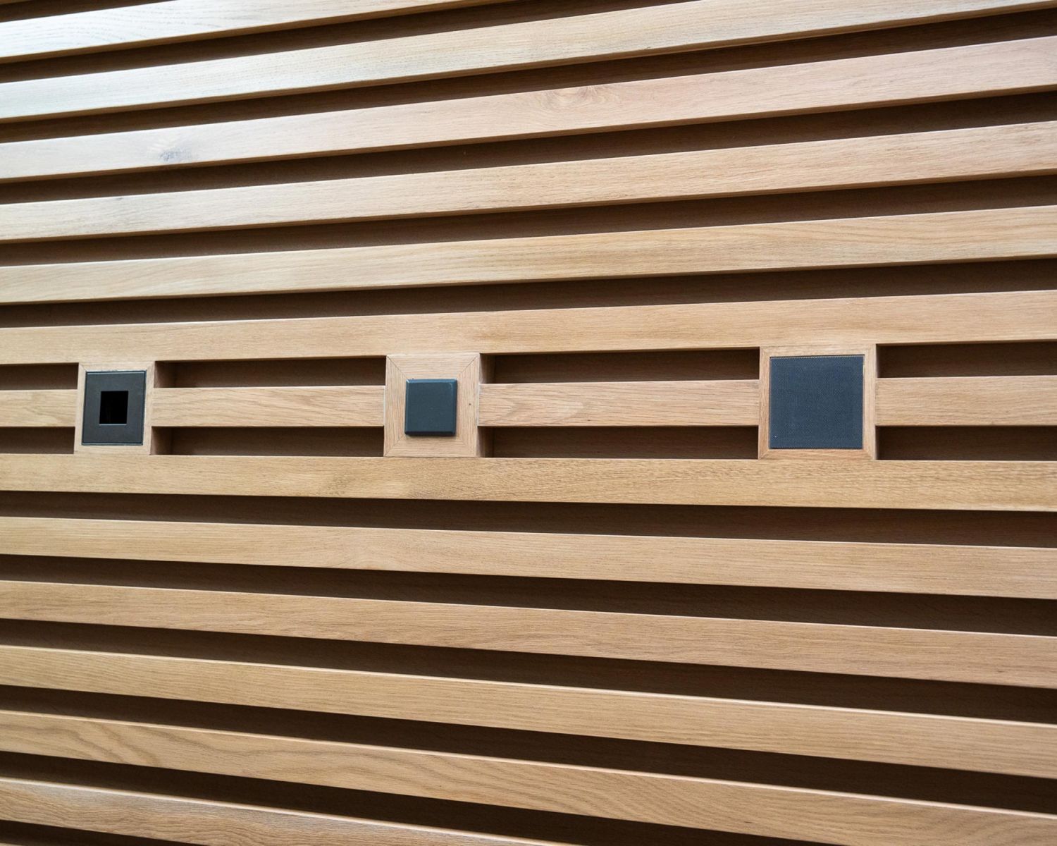 Wood slat wall with integrated speakers and outlets
