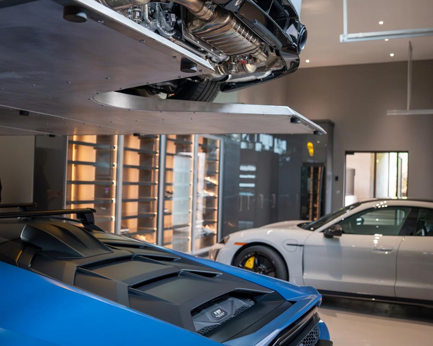 Underside view of raised sports car above garage floor