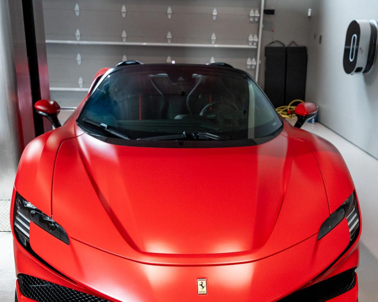 Garage lounge area with seating and sports car in background