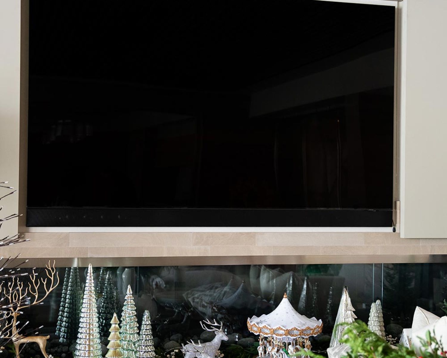 Wall mounted TV above decorative shelving and seasonal decor