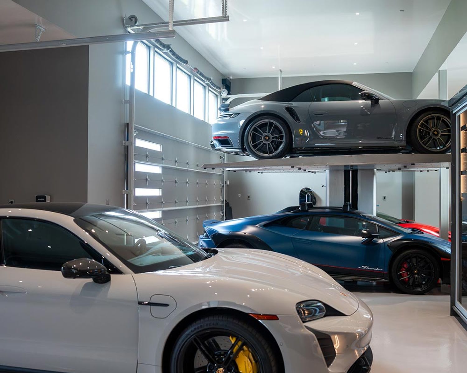 Luxury garage with multiple sports cars and vehicle lift