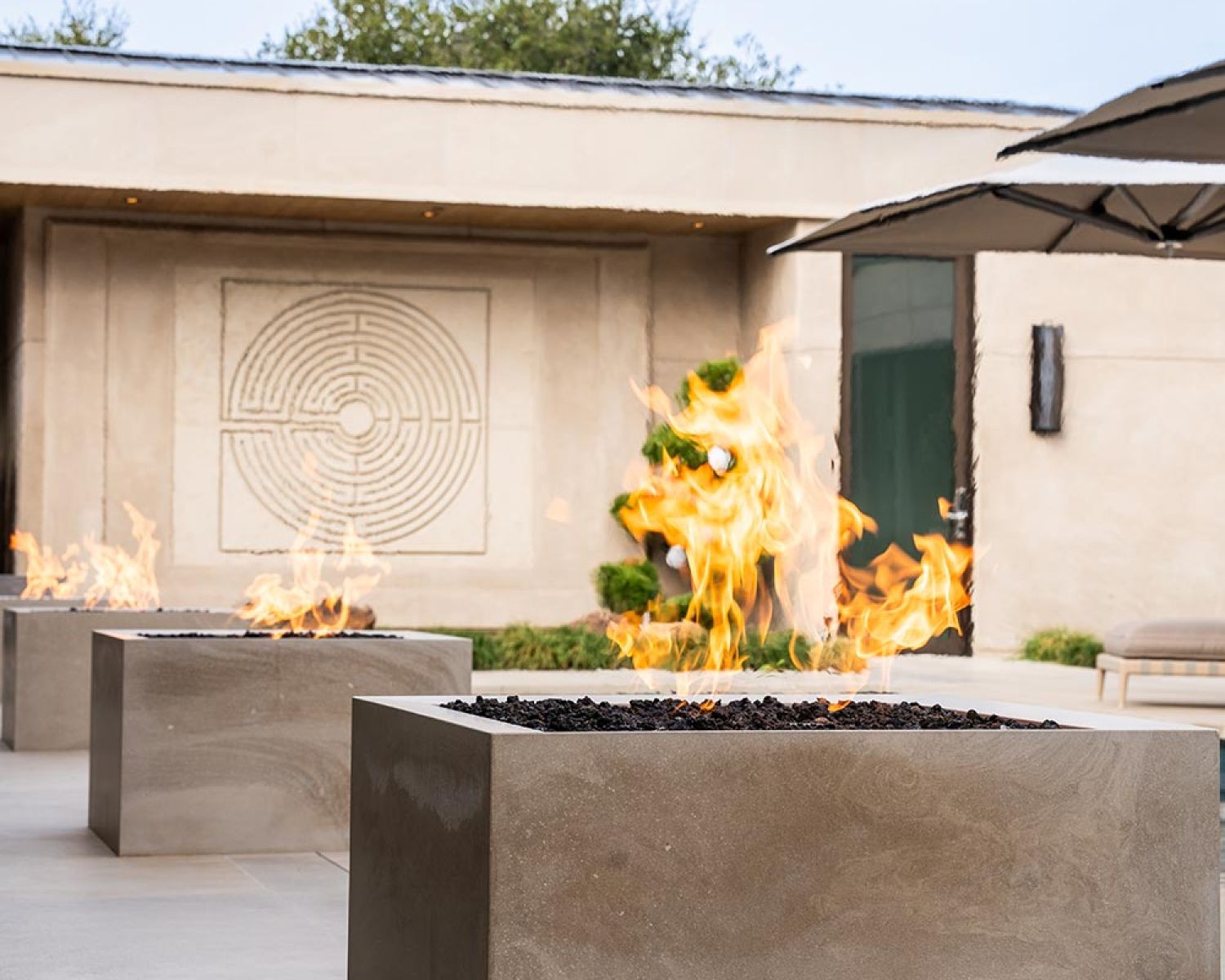 Outdoor fire feature with pool and modern patio backdrop