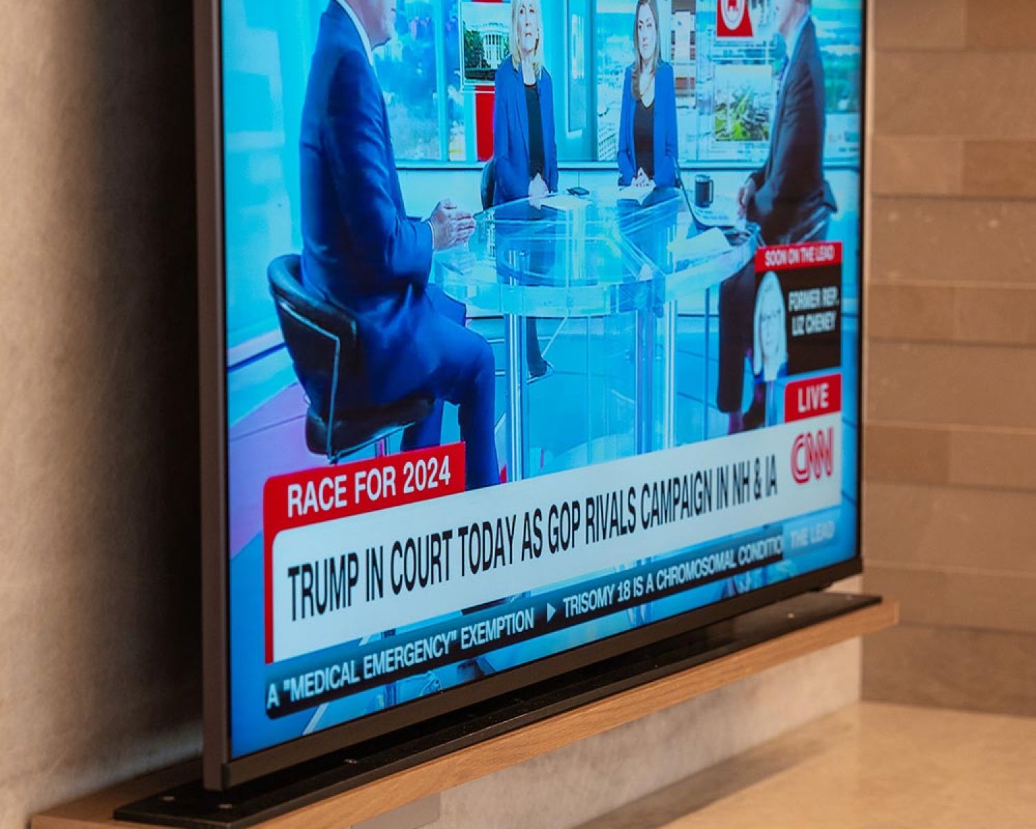 Wall mounted TV displaying news in modern media niche