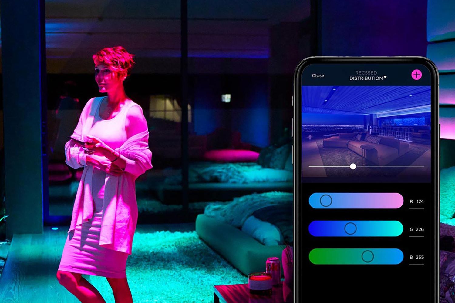 Woman using smartphone to adjust colorful smart lighting in a modern room