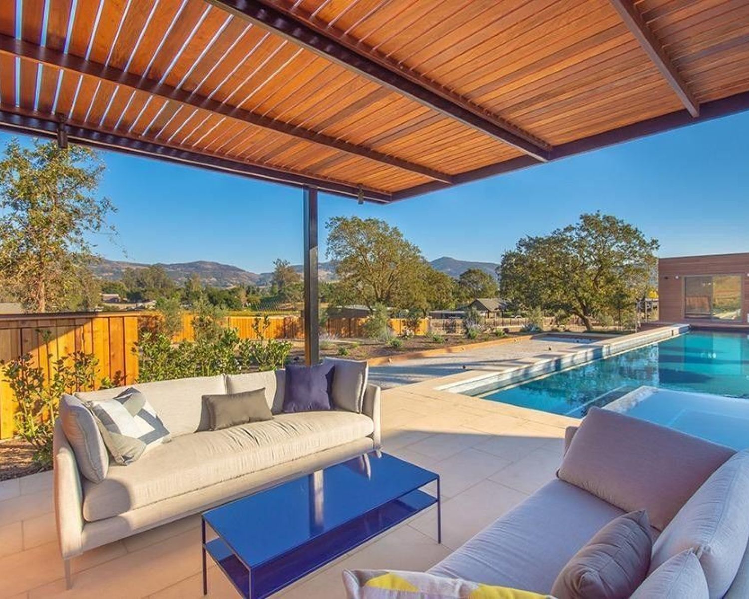 patio next to swimming pool beneath wooden slats