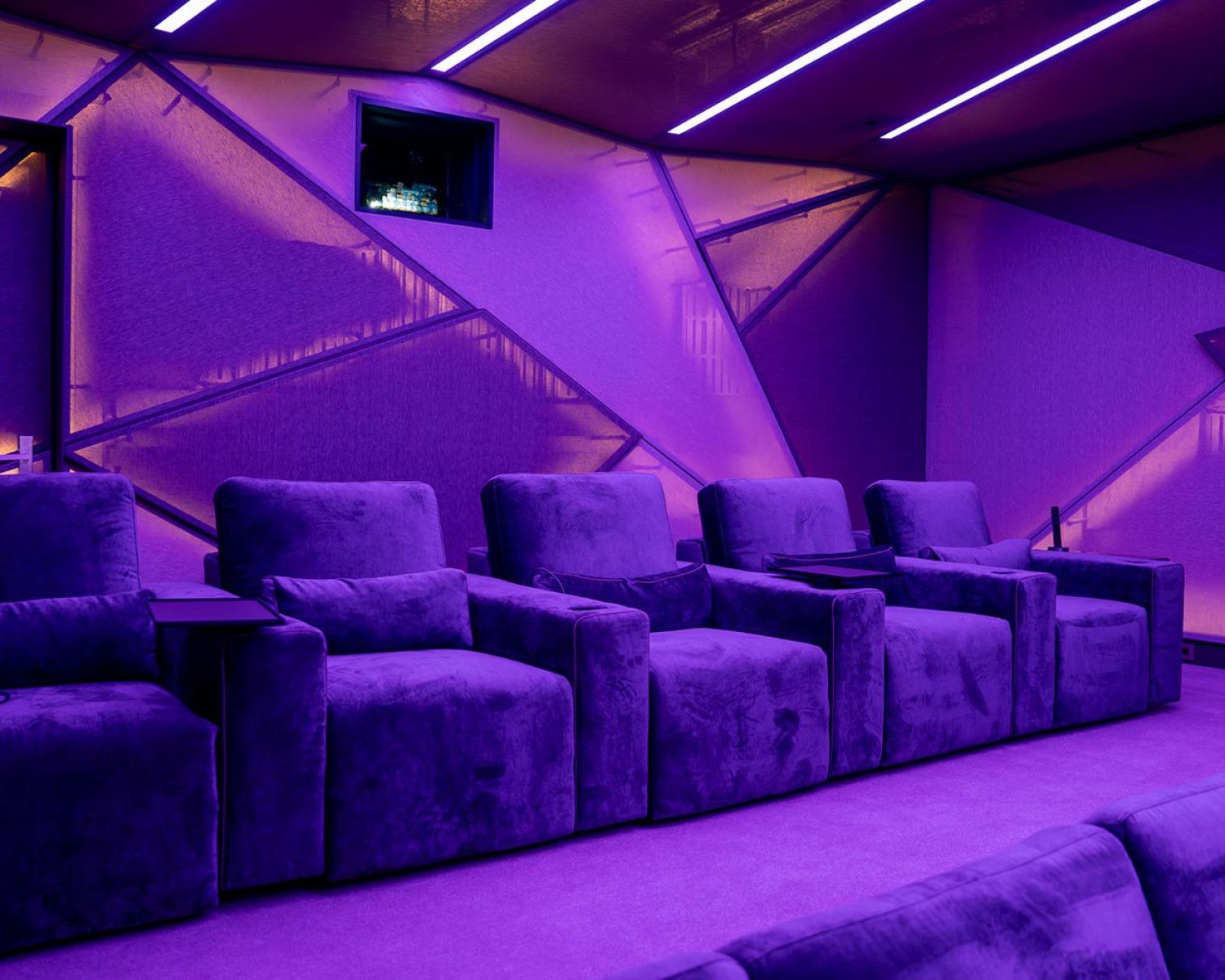 Home theater seating with purple accent lighting and geometric acoustic walls