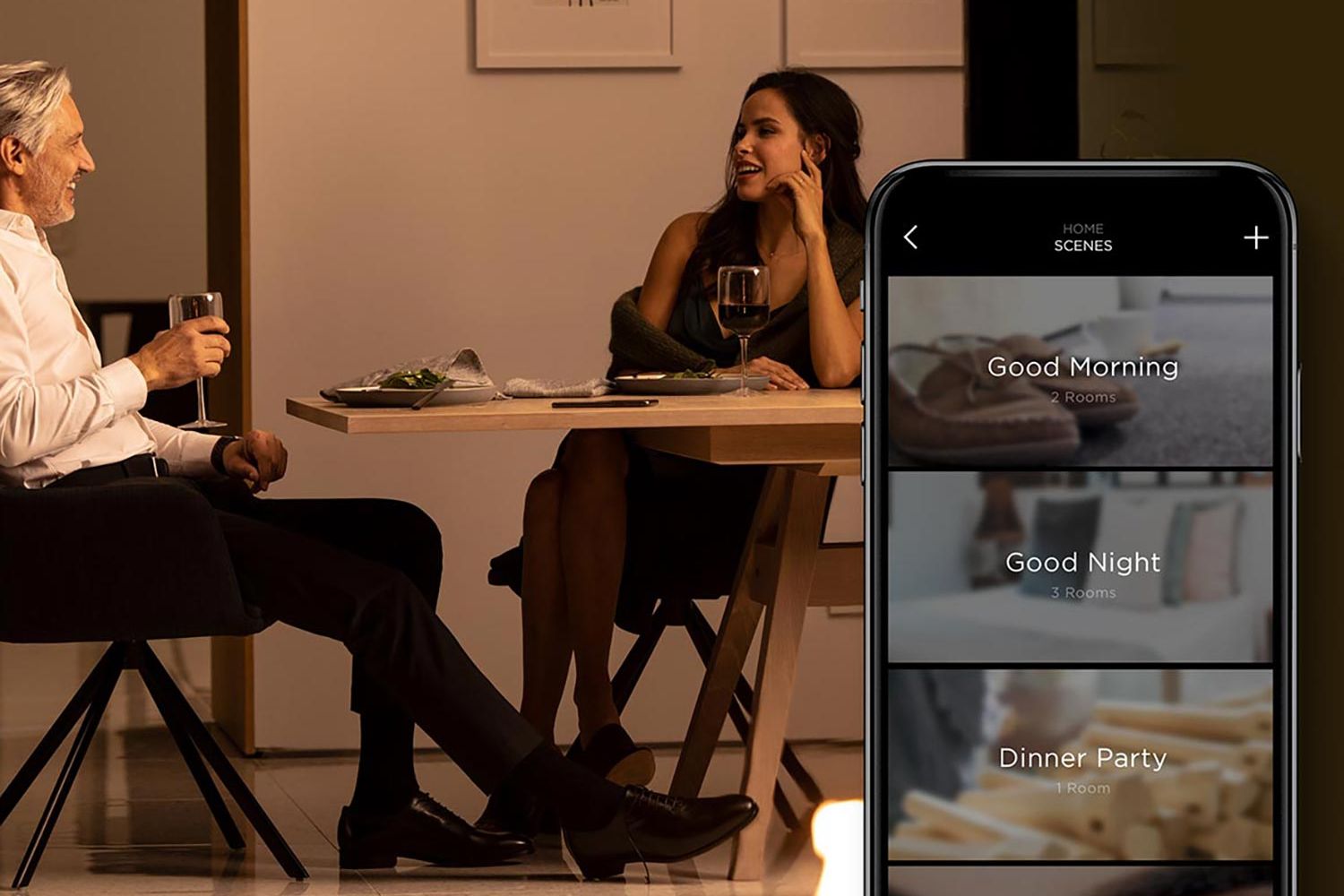 Couple having dinner with Savant app showing lighting scene options on phone screen