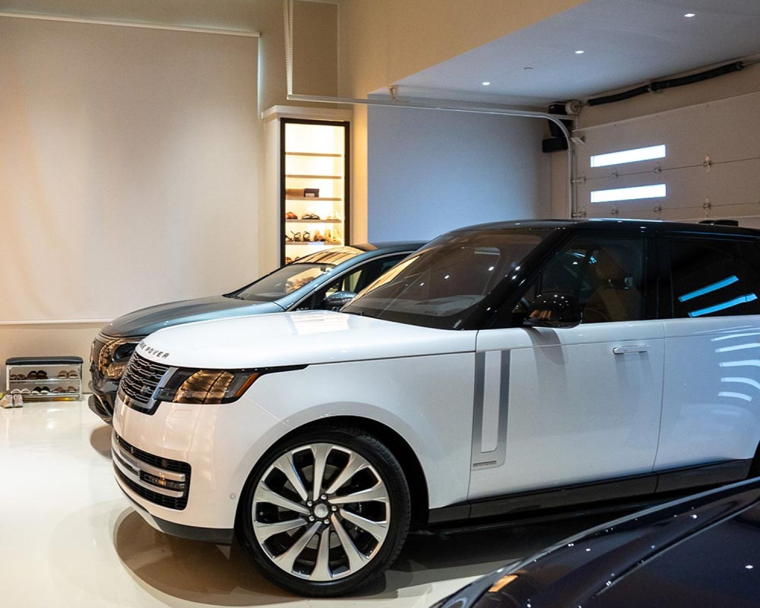 Indoor garage space with luxury SUVs parked side by side
