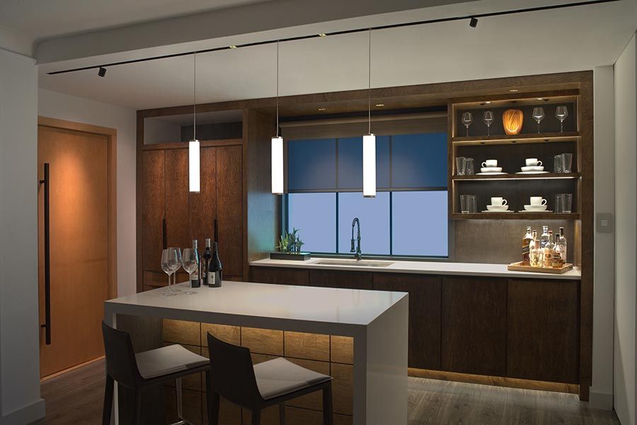 Pendant lights enhance a cozy kitchen with wood cabinetry